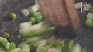 鍋中油7成熱時(shí)，入青豆、筍丁翻炒，然后加糯米飯加鹽均勻翻炒。