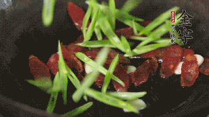 先后下香腸片、四季豆絲均勻翻炒，加適量清水燜煮一下。