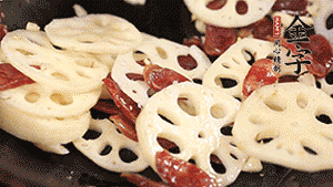 依次下香腸片、藕片翻炒均勻，加適量清水燜熟。