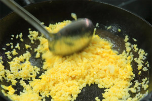 大火加熱炒鍋，再入油，燒到四至五成熱時倒入雞蛋液，在未凝結(jié)之前，加米飯煸炒，不停翻炒并用鍋鏟將成塊的米飯碾開、撥散。