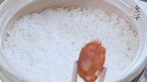 煮開后轉(zhuǎn)小火，當(dāng)米飯出現(xiàn)小孔時，鋪上金字麻辣香腸。