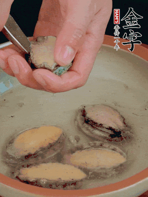 鮑魚加鹽、清水浸泡，用勺子挖出鮑魚肉。