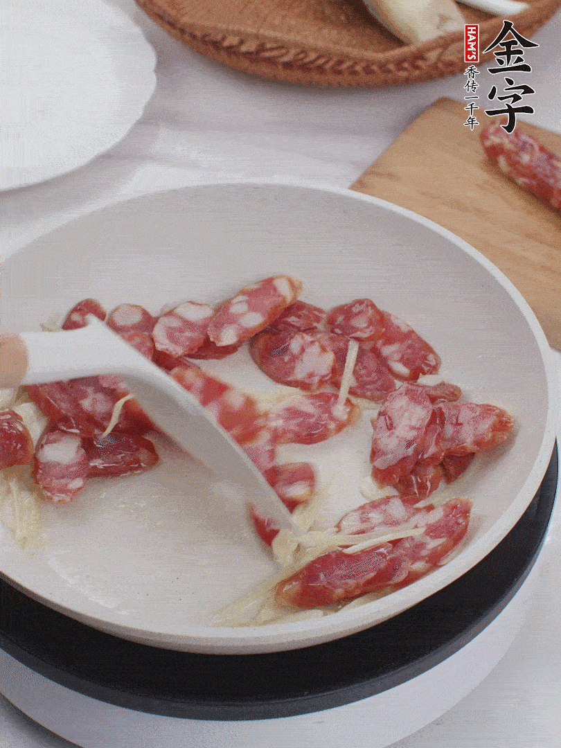 油溫3成熱時，下姜絲、蒜片、香腸炒出油脂。