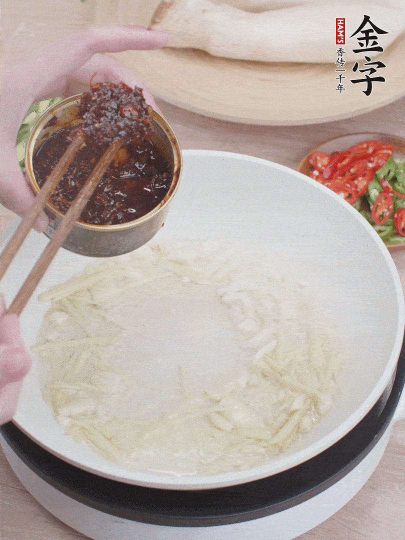 起鍋熱油，姜蒜、金字火腿干貝醬煸香。