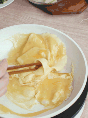 油6成熱時(shí)，下雞蛋液，邊緣凝固時(shí)翻拌成塊狀。