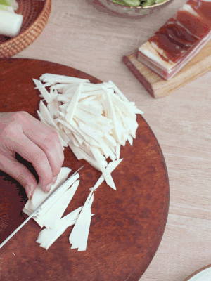茭白切細絲，鹽水中浸泡防止氧化。