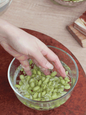 青豆剝殼，搓去外衣。