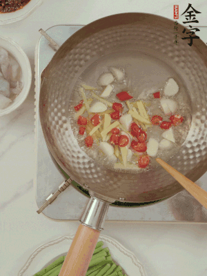 油7成熱時(shí)，下大蒜粒、姜絲、小米辣煸香。