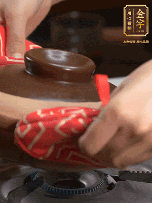 中火調成小火，鋪上香腸蓋蓋燜5分鐘。不斷轉動瓦煲，讓側壁的飯形成飯焦