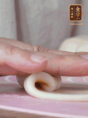 做面劑 油皮按扁，中間包入一個油酥，邊緣收緊捏死。包好的面劑按扁，用搟面杖搟壓成橢圓形。從底部向上卷成筒狀，用保鮮膜蓋好松弛15分鐘，再把筒狀縱向搟壓成長條狀。再卷一次，松弛20分鐘