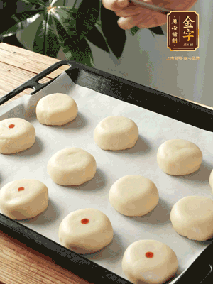 收口向下放在案板上，輕輕將月餅坯按扁，用筷子點紅點做裝飾
