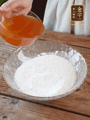 轉(zhuǎn)化糖漿、枧水、花生油攪拌均勻，加入面粉混合，醒發(fā)2小時。捏成23g一個的小球