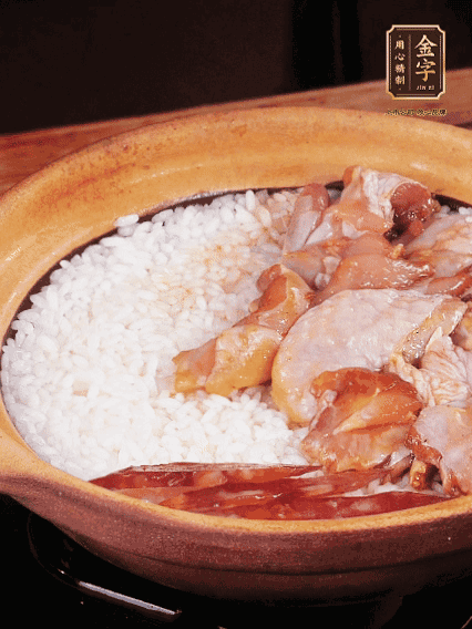 煮到椰子水微微收干轉小火，快速均勻鋪上雞肉、金字香腸