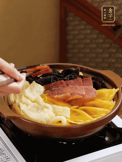 砂鍋底部鋪上娃娃菜，依次擺上肉皮、蛋餃、黑木耳、火腿